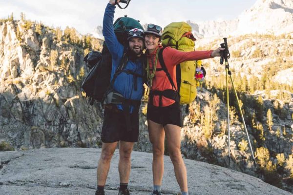 Two people smiling on a beginner backpacking trip in the Sierra Nevada mountains