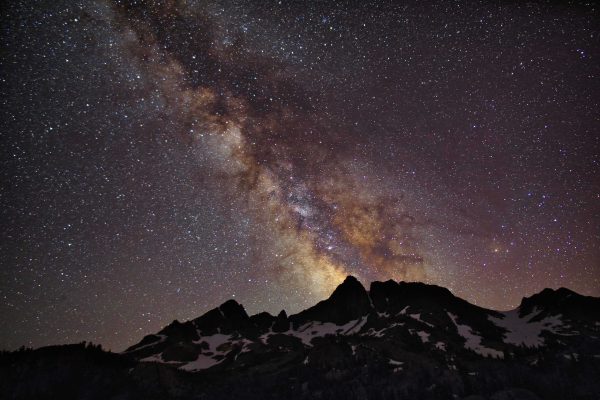 Starry night sky above mountain peaks in Tuolumne Meadows